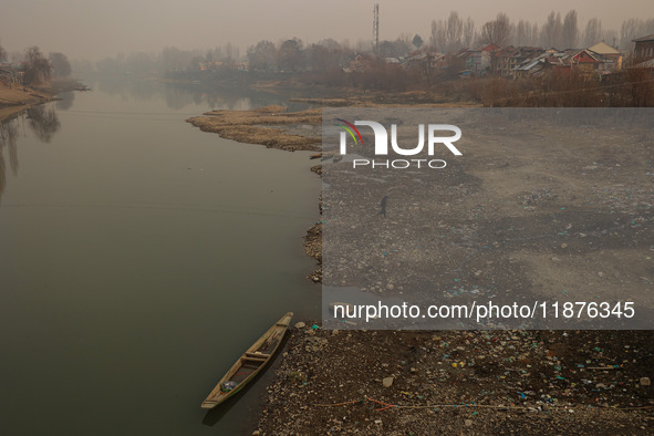 A man walks toward the shore of River Jehlum on a cold winter day in Baramulla, Jammu and Kashmir, India, on December 17, 2024. 