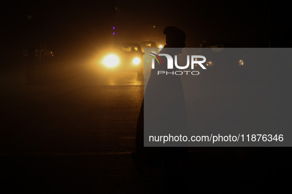 A man crosses a road during a winter evening in Sopore, Jammu and Kashmir, India, on December 17, 2024. 