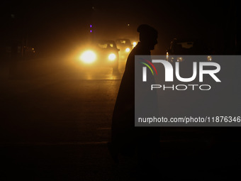 A man crosses a road during a winter evening in Sopore, Jammu and Kashmir, India, on December 17, 2024. (