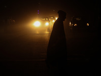 A man crosses a road during a winter evening in Sopore, Jammu and Kashmir, India, on December 17, 2024. (