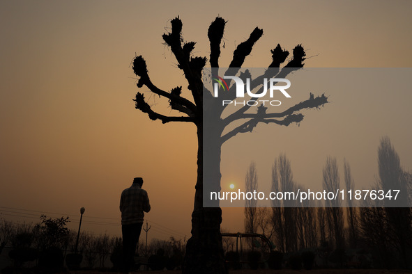 A boy walks as the sun appears on a cold winter day in Baramulla, Jammu and Kashmir, India, on December 17, 2024. 