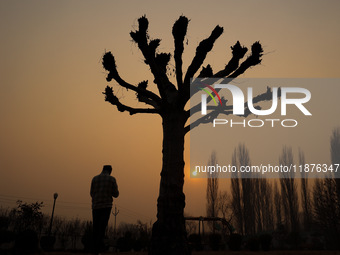 A boy walks as the sun appears on a cold winter day in Baramulla, Jammu and Kashmir, India, on December 17, 2024. (