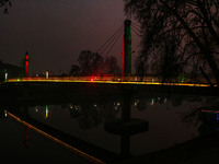 People walk over the river Jhelum bridge on a cold evening in Srinagar, Jammu and Kashmir, on December 17, 2024. Cold wave conditions intens...