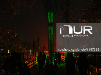 People walk over the river Jhelum bridge on a cold evening in Srinagar, Jammu and Kashmir, on December 17, 2024. Cold wave conditions intens...