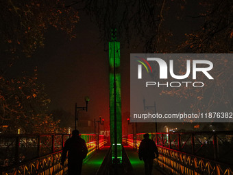 People walk over the river Jhelum bridge on a cold evening in Srinagar, Jammu and Kashmir, on December 17, 2024. Cold wave conditions intens...