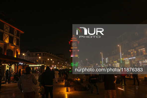 Indian tourists and local people walk near the Clock Tower (Ghanta Ghar) on a cold evening in Srinagar, Jammu and Kashmir, on December 17, 2...