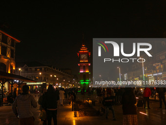 Indian tourists and local people walk near the Clock Tower (Ghanta Ghar) on a cold evening in Srinagar, Jammu and Kashmir, on December 17, 2...