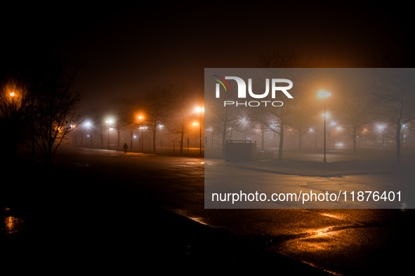 A person walks through dense fog that covers Liberty State Park following rainfall in Jersey City, NJ, U.S., on December 16, 2024. 