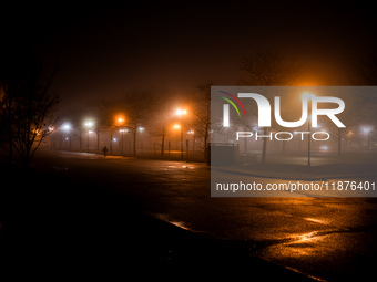 A person walks through dense fog that covers Liberty State Park following rainfall in Jersey City, NJ, U.S., on December 16, 2024. (