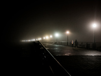 Runners move through dense fog covering Liberty State Park following rainfall in Jersey City, NJ, U.S., on December 16, 2024. (