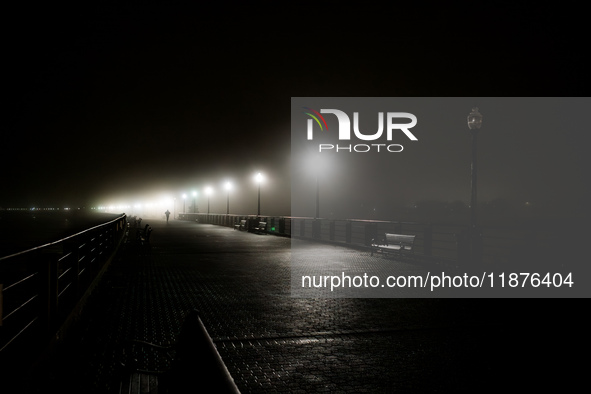 A runner moves through dense fog covering Liberty State Park following rainfall in Jersey City, NJ, U.S., on December 16, 2024. 