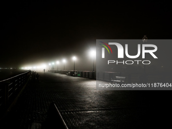 A runner moves through dense fog covering Liberty State Park following rainfall in Jersey City, NJ, U.S., on December 16, 2024. (