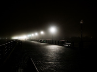 A runner moves through dense fog covering Liberty State Park following rainfall in Jersey City, NJ, U.S., on December 16, 2024. (