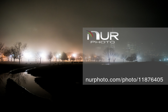 Part of the New York City skyline is seen through dense fog covering Liberty State Park following rainfall in Jersey City, NJ, U.S., on Dece...