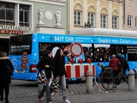 Festive decorations and shoppers appear during the holiday season in Augsburg, Bavaria, Germany, on December 14, 2024. A blue public bus wit...