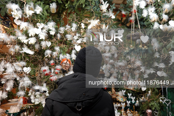 A customer explores handcrafted decorations while the saleswoman looks on at Augsburg Christmas Market in Bavaria, Germany, on December 14,...