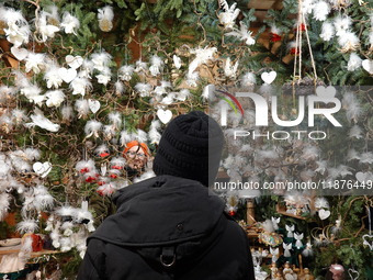 A customer explores handcrafted decorations while the saleswoman looks on at Augsburg Christmas Market in Bavaria, Germany, on December 14,...