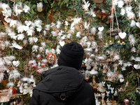 A customer explores handcrafted decorations while the saleswoman looks on at Augsburg Christmas Market in Bavaria, Germany, on December 14,...