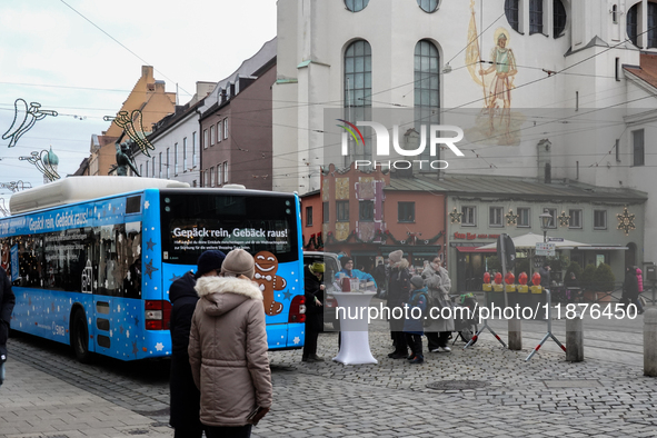 Festive decorations and shoppers appear during the holiday season in Augsburg, Bavaria, Germany, on December 14, 2024. A blue public bus wit...