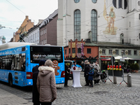 Festive decorations and shoppers appear during the holiday season in Augsburg, Bavaria, Germany, on December 14, 2024. A blue public bus wit...