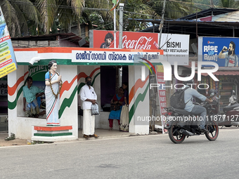 People wait at a bus stand near a statue of the former Prime Minister of India, Indira Gandhi, in Thiruvananthapuram, Kerala, India, on Apri...