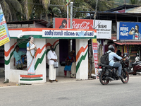 People wait at a bus stand near a statue of the former Prime Minister of India, Indira Gandhi, in Thiruvananthapuram, Kerala, India, on Apri...