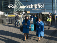 Entrance of Amsterdam Airport Schiphol AMS EHAM airport terminal with passenger and flight crew walking by and the logo inscription over the...