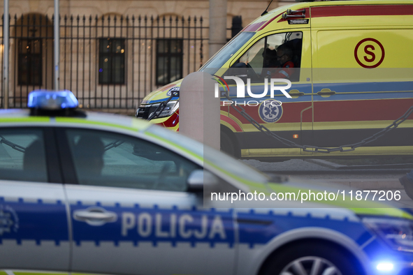 An ambulance and a police car with lights on are on the street in Warsaw, Poland, on December 12, 2024. 