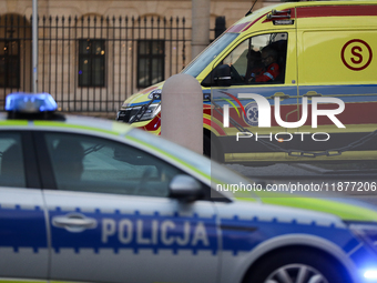 An ambulance and a police car with lights on are on the street in Warsaw, Poland, on December 12, 2024. (