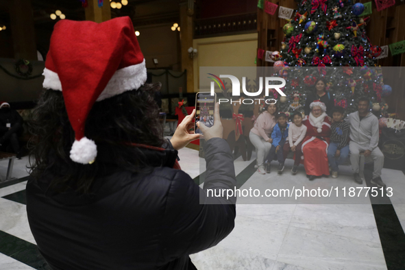 Mrs. Claus poses with several people inside the Mexican Postal Service at the Postal Palace in the Zocalo of Mexico City, Mexico, on Decembe...