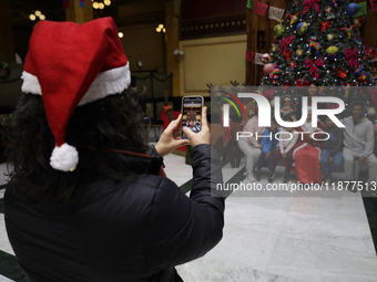 Mrs. Claus poses with several people inside the Mexican Postal Service at the Postal Palace in the Zocalo of Mexico City, Mexico, on Decembe...