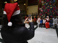 Mrs. Claus poses with several people inside the Mexican Postal Service at the Postal Palace in the Zocalo of Mexico City, Mexico, on Decembe...