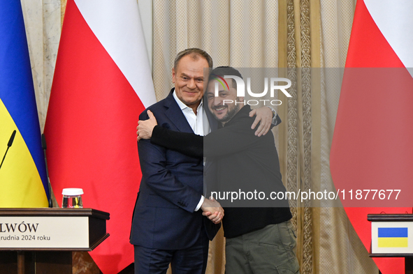 President of Ukraine Volodymyr Zelenskyy and Polish Prime Minister Donald Tusk hug as they pose for a photo at the end of a joint press conf...