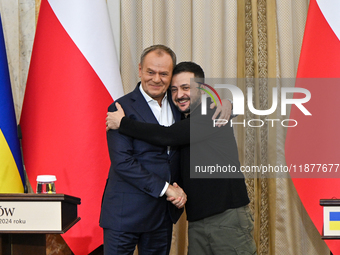 President of Ukraine Volodymyr Zelenskyy and Polish Prime Minister Donald Tusk hug as they pose for a photo at the end of a joint press conf...