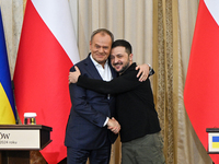 President of Ukraine Volodymyr Zelenskyy and Polish Prime Minister Donald Tusk hug as they pose for a photo at the end of a joint press conf...