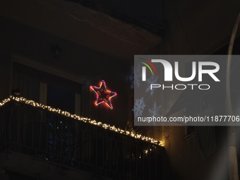 Christmas lights and snowflake-shaped lighting are on a balcony in Athens, Greece, on December 16, 2024. (