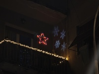 Christmas lights and snowflake-shaped lighting are on a balcony in Athens, Greece, on December 16, 2024. (