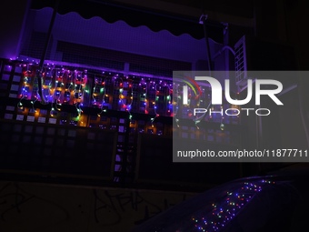 A garland with Christmas lights is on a balcony in Athens, Greece, on December 16, 2024. (