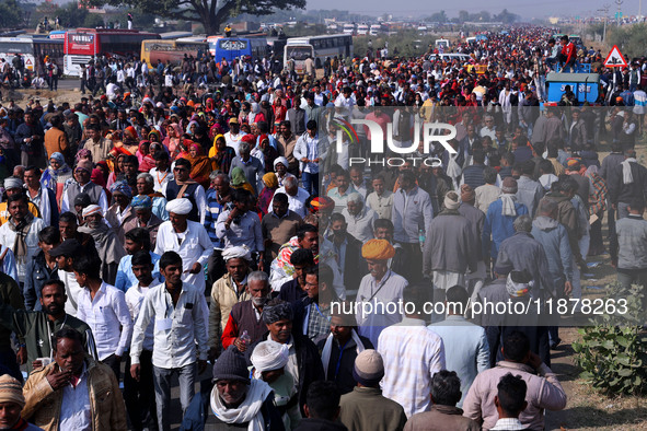 People arrive to attend Prime Minister Narendra Modi's public meeting for the 'Ek Varsh-Parinaam Utkarsh' event, marking the completion of o...