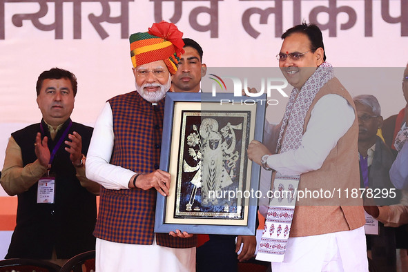 Prime Minister Narendra Modi is welcomed by Rajasthan Chief Minister Bhajan Lal Sharma during the 'Ek Varsh-Parinaam Utkarsh' event, marking...