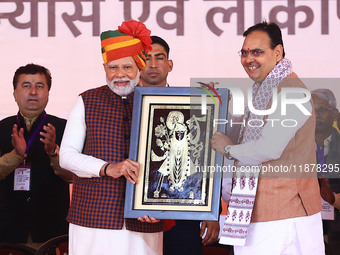 Prime Minister Narendra Modi is welcomed by Rajasthan Chief Minister Bhajan Lal Sharma during the 'Ek Varsh-Parinaam Utkarsh' event, marking...