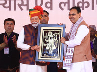 Prime Minister Narendra Modi is welcomed by Rajasthan Chief Minister Bhajan Lal Sharma during the 'Ek Varsh-Parinaam Utkarsh' event, marking...