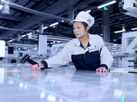 A worker produces solar photovoltaic products at a digital workshop in Suqian, Jiangsu province, China, on December 17, 2024. (