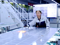 A worker produces solar photovoltaic products at a digital workshop in Suqian, Jiangsu province, China, on December 17, 2024. (