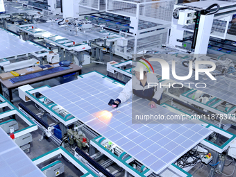 A worker produces solar photovoltaic products at a digital workshop in Suqian, Jiangsu province, China, on December 17, 2024. (