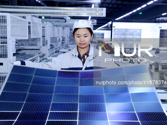 A worker produces solar photovoltaic products at a digital workshop in Suqian, Jiangsu province, China, on December 17, 2024. (