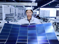 A worker produces solar photovoltaic products at a digital workshop in Suqian, Jiangsu province, China, on December 17, 2024. (