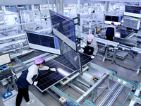 A worker produces solar photovoltaic products at a digital workshop in Suqian, Jiangsu province, China, on December 17, 2024. (