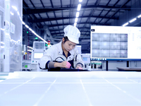 A worker produces solar photovoltaic products at a digital workshop in Suqian, Jiangsu province, China, on December 17, 2024. (