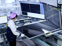 A worker produces solar photovoltaic products at a digital workshop in Suqian, Jiangsu province, China, on December 17, 2024. (